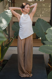 Pantalón fluido de fit recto, con pinzas frontales, cintura alta con pretina elástica posterior, bolsillos delanteros, cierre frontal con botón y cremallera oculta.