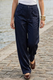 Pantalón fluido de fit wide leg, cintura alta con pretina y trabillas, bolsillos decorativos delanteros y traseros con cartera, costuras frontales decorativas, cierre frontal con botón y cremallera oculta.