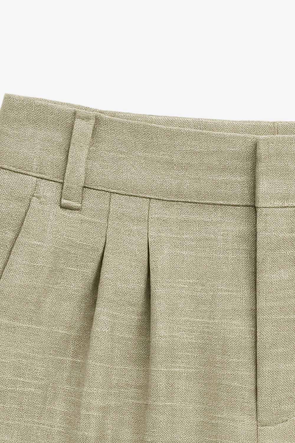 Pantalón de fit wide leg, cintura alta, con pretina y trabillas, bolsillos delanteros, pinzas frontales, cierre frontal con broche y cremallera ocultas.