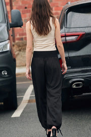 Pantalón de fit balloon, cintura media elástica con pretina fruncida, bolsillos delanteros y bajo globo con jaretas ajustables.
