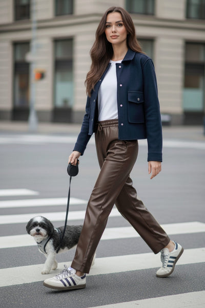 Pantalón de efecto piel, fit recto, bolsillos delanteros, cintura alta con pretina elástica y jareta frontal ajustable. Detalle de costuras posteriores decorativas.