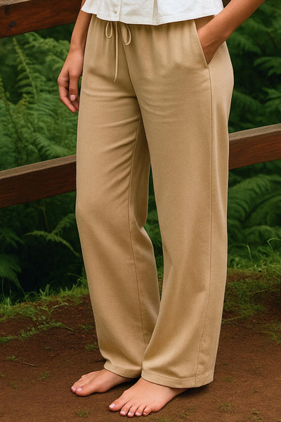 Pantalón fluido de lino, fit recto, bolsillos delanteros, cintura media con pretina elástica y jareta frontal ajustable.