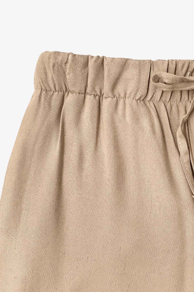 Pantalón fluido de lino, fit recto, bolsillos delanteros, cintura media con pretina elástica y jareta frontal ajustable.