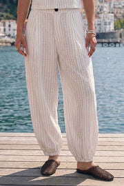 Pantalón de fit balloon, estampado rayas, cintura media con pretina elástica posterior, bolsillos delanteros, pinzas frontales y bajo globo con rib elástico. Cierre frontal con botón y cremallera oculta.