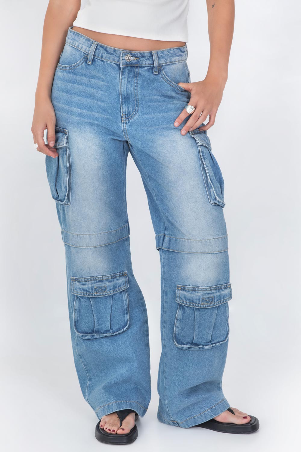 Pantalón multipocket cargo de denim, cintura alta con pretina y trabillas, de fit wide leg, bolsillos delanteros, laterales cargo y posteriores decorativos con cartera. Detalle cortes con costura en rodilla, cierre frontal con botón y cremallera oculta.