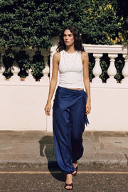 Pantalón satinado de fit balloon, cintura media elástica, bolsillos delanteros, detalle de pareo decorativo con plisados y nudo lateral.