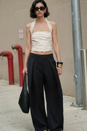 Pantalón wide leg de cintura alta con pretina y trabillas, pinzas con detalle decorativo frontal, bolsillos delanteros y vivos decorativos posteriores. Cierre frontal con broche y cremallera ocultos.