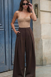 Pantalón wide leg de cintura alta con pretina y trabillas, pinzas con detalle decorativo frontal, bolsillos delanteros y vivos decorativos posteriores. Cierre frontal con broche y cremallera ocultos.