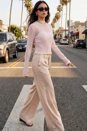 Pantalón satinado de fit recto, cintura alta con pretina y trabillas, bolsillos delanteros y vivos decorativos posteriores, pinzas frontales. Cierre con botón y cremallera oculta.