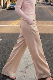 Pantalón satinado de fit recto, cintura alta con pretina y trabillas, bolsillos delanteros y vivos decorativos posteriores, pinzas frontales. Cierre con botón y cremallera oculta.