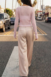 Pantalón satinado de fit recto, cintura alta con pretina y trabillas, bolsillos delanteros y vivos decorativos posteriores, pinzas frontales. Cierre con botón y cremallera oculta.