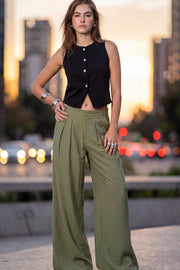 Pantalón de fit wide leg, cintura alta con pretina y trabillas, pinzas frontales, bolsillos delanteros, cierre frontal con broche y cremallera ocultos.