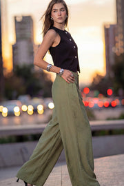 Pantalón de fit wide leg, cintura alta con pretina y trabillas, pinzas frontales, bolsillos delanteros, cierre frontal con broche y cremallera ocultos.