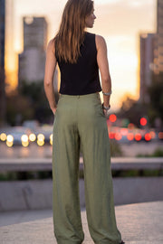 Pantalón de fit wide leg, cintura alta con pretina y trabillas, pinzas frontales, bolsillos delanteros, cierre frontal con broche y cremallera ocultos.