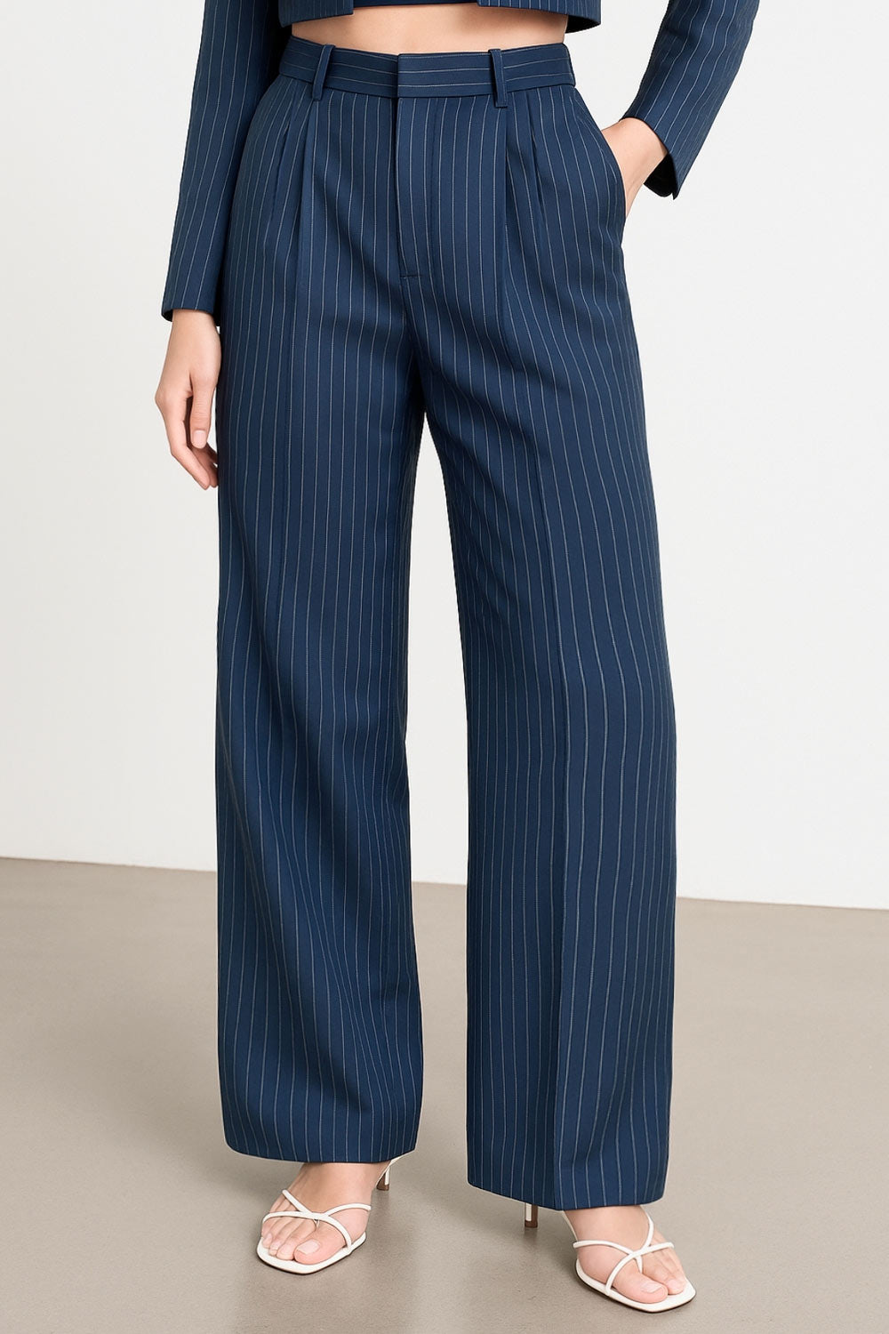 Pantalón de fit wide leg, estampado rayas, cintura alta con pretina y trabillas, pinzas frontales, bolsillos delanteros y vivo decorativo posterior. Cierre frontal con broche y cremallera ocultos.