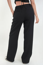 Pantalón de fit recto, cintura alta con pretina y trabillas, bolsillos delanteros y vivos decorativos posteriores. Detalle de raya frontal, cierre con broche y cremallera ocultos.
