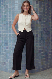 Pantalón cropped de fit recto, cintura media con pretina y trabillas, bolsillos delanteros y posteriores de parche. Detalle de raya frontal y posterior, doblez en bajo, cierre frontal con broche y cremallera oculta.