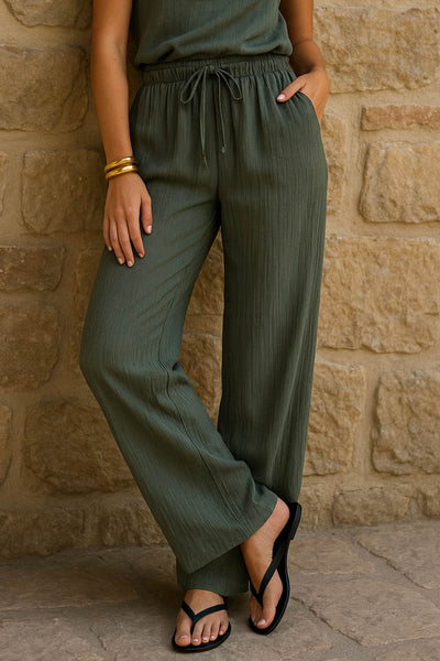 Pantalón de fit fluido, bolsillos delanteros, cintura media con pretina elástica y jareta frontal ajustable.