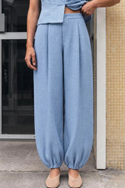 Pantalón de fit balloon, cintura alta con pretina elástica posterior, bolsillos delanteros y rib elástico en bajo. Cierre frontal con broche y cremallera ocultos.