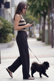 Pantalón de fit wide leg, cintura alta con pretina y trabillas, pinzas frontales, bolsillos delanteros y vivos decorativos posteriores. Cierre frontal con botón y cremallera oculta.