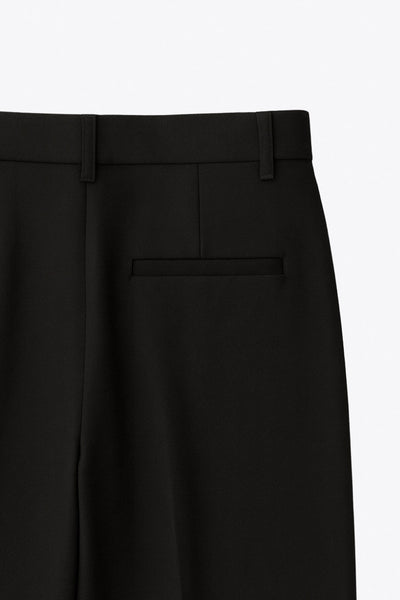 Pantalón de fit wide leg, cintura alta con pretina y trabillas, pinzas frontales, bolsillos delanteros y vivo decorativo posterior. Cierre con botón y cremallera oculta.