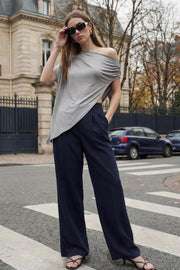Pantalón de fit wide leg, cintura alta con pretina elástica posterior y trabillas, pinzas frontales, bolsillos delanteros y vivo decorativo posterior. Cierre frontal con broche y cremallera ocultos. Detalle de raya frontal y posterior.
