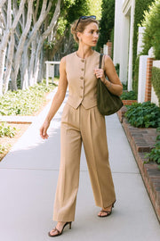 Pantalón de fit wide leg, cintura alta con pretina elástica posterior y trabillas, pinzas frontales, bolsillos delanteros y vivo decorativo posterior. Cierre frontal con broche y cremallera ocultos. Detalle de raya frontal y posterior.