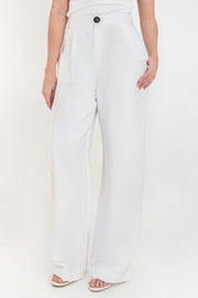 Pantalón de fit wide leg, pinzas frontales, bolsillos delanteros, cintura alta con pretina elástica posterior, cierre frontal con cremallera oculta y botón en contraste.