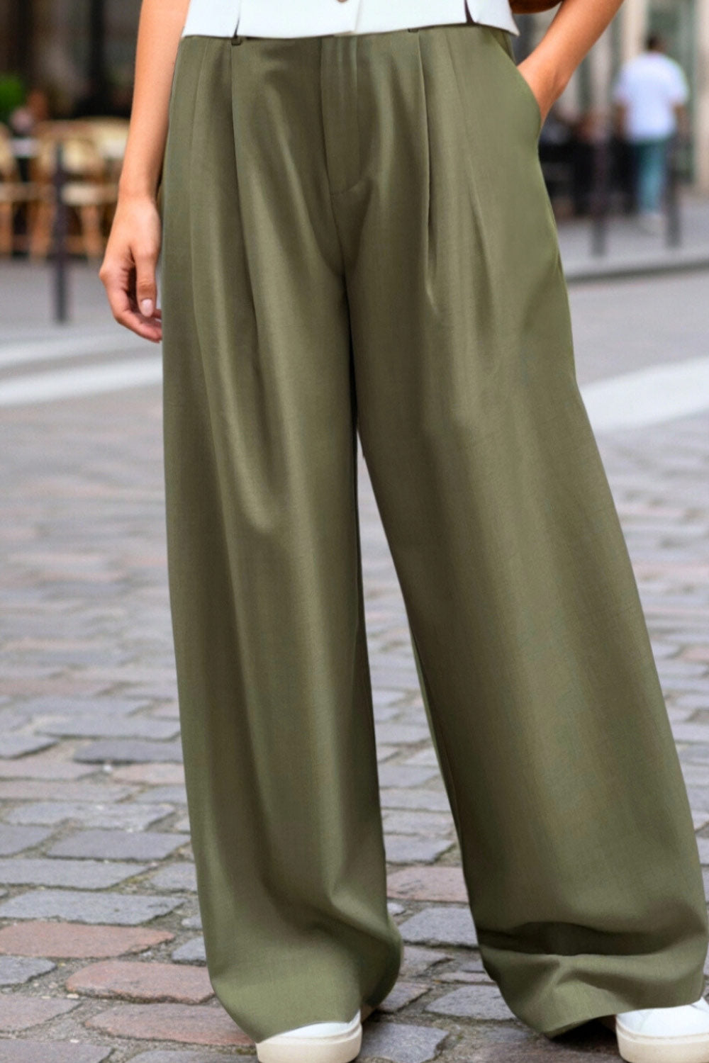 Pantalón de fit wide leg, cintura media con pretina, trabillas ajustables laterales, pinzas frontales, bolsillos delanteros y vivos decorativos posteriores. Cierre frontal con broche y cremallera ocultos.