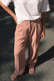 Pantalón de fit wide leg, cintura alta con pretina, pinzas frontales, bolsillos delanteros y vivos decorativos posteriores. Cierre frontal con broche y cremallera ocultos. Detalle v en pretina posterior.