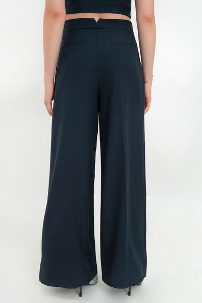 Pantalón de fit wide leg, cintura alta con pretina, pinzas frontales, bolsillos delanteros y vivos decorativos posteriores. Cierre frontal con broche y cremallera ocultos. Detalle v en pretina posterior.