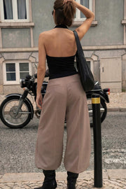 Pantalón de fit wide leg, cintura alta con pretina, pinzas frontales, bolsillos delanteros y vivos decorativos posteriores. Cierre frontal con broche y cremallera ocultos. Detalle v en pretina posterior.