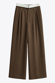 Pantalón de fit wide leg, pinzas frontales, cintura media, pretina con detalle de tailoring en contraste, bolsillos delanteros y vivos decorativos posteriores. Cierre frontal con broche y cremallera ocultos.
