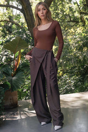 Pantalón de estampado rayas, fit wide leg, pinzas frontales, cintura alta y cruce frontal con lazo amarrable lateral. Detalle decorativo en pretina frontal.