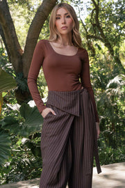 Pantalón de estampado rayas, fit wide leg, pinzas frontales, cintura alta y cruce frontal con lazo amarrable lateral. Detalle decorativo en pretina frontal.