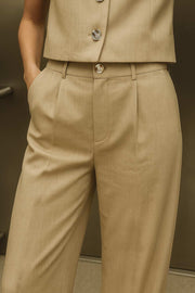 Pantalón de fit wide leg, pinzas frontales, cintura alta con pretina y trabillas, bolsillos delanteros y posteriores con vivos. Cierre frontal con botón y cremallera oculta.