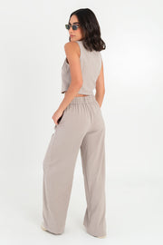 Pantalón de fit wide leg, cintura alta con pretina elástica posterior, trabillas, pinzas frontales y bolsillos delanteros.