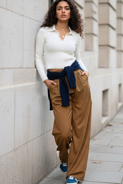 Pantalón de fit wide leg, cintura alta con pretina elástica posterior, trabillas, pinzas frontales y bolsillos delanteros.