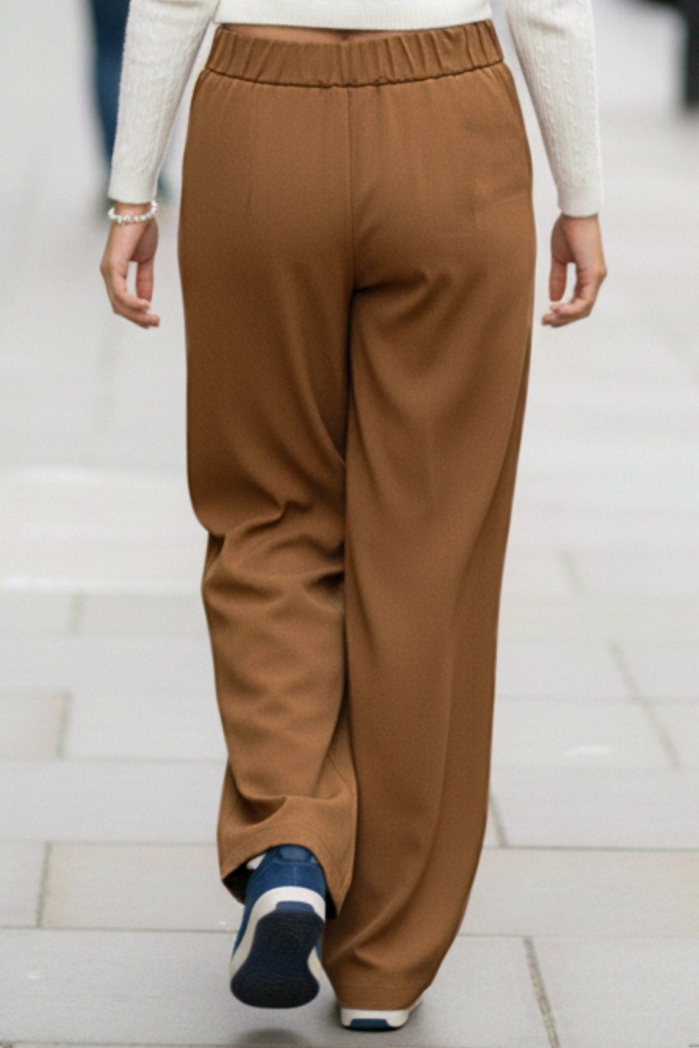 Pantalón de fit wide leg, cintura alta con pretina elástica posterior, trabillas, pinzas frontales y bolsillos delanteros.