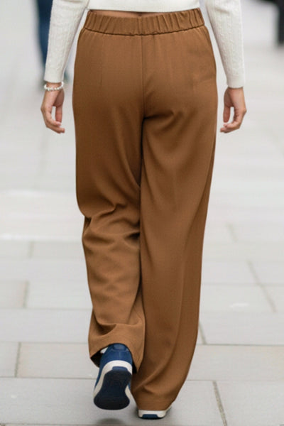 Pantalón de fit wide leg, cintura alta con pretina elástica posterior, trabillas, pinzas frontales y bolsillos delanteros.