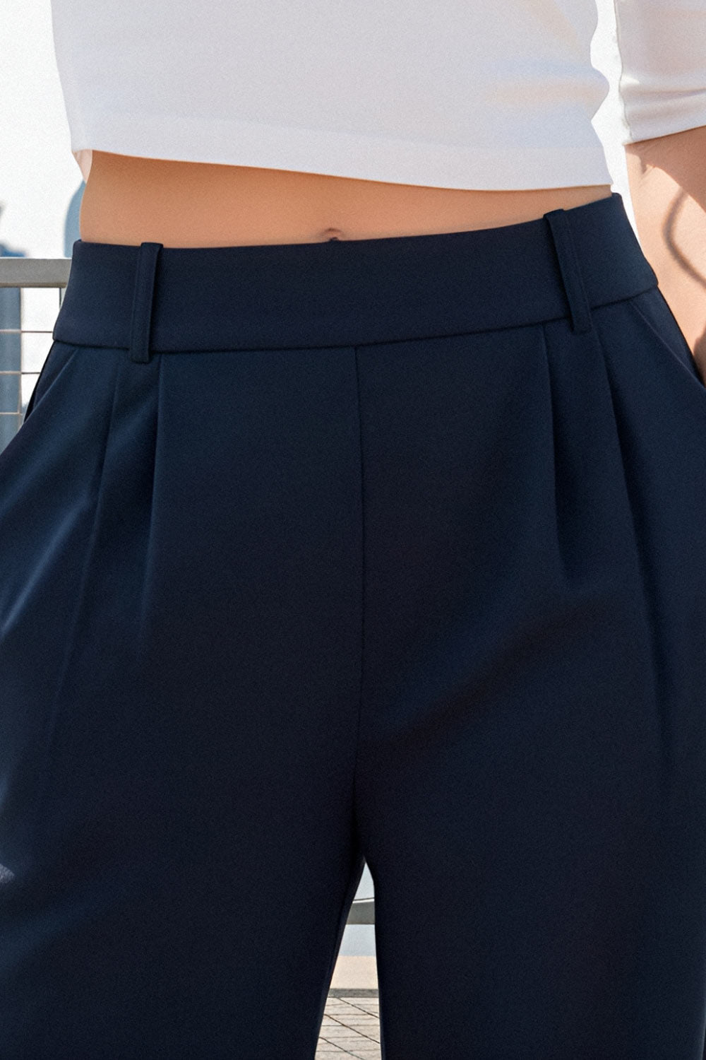 Pantalón de fit wide leg, cintura alta con pretina elástica posterior, trabillas, pinzas frontales y bolsillos delanteros.