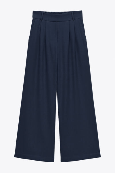 Pantalón de fit wide leg, cintura alta con pretina elástica posterior, trabillas, pinzas frontales y bolsillos delanteros.