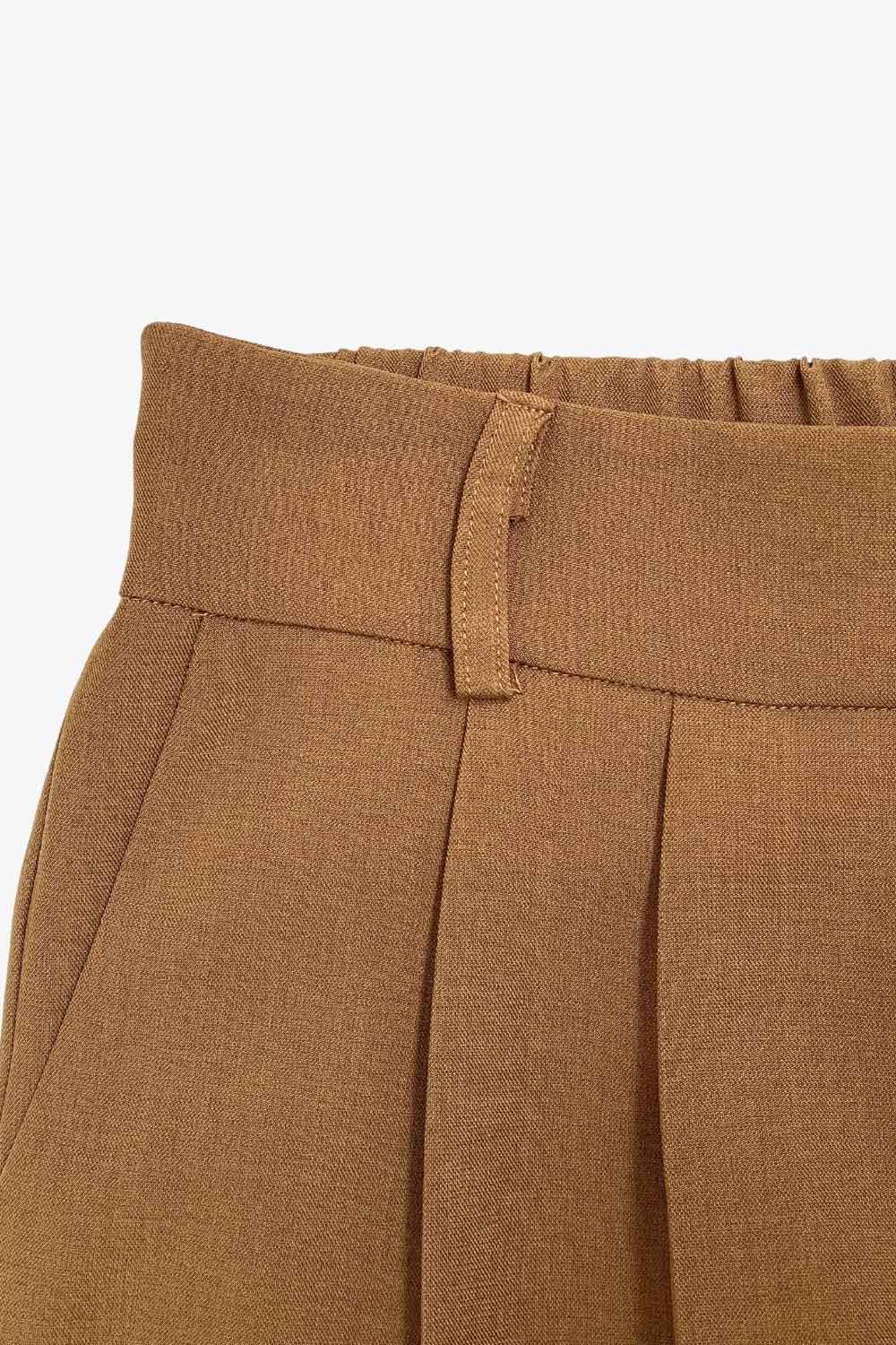 Pantalón de fit wide leg, cintura alta con pretina elástica posterior, trabillas, pinzas frontales y bolsillos delanteros.