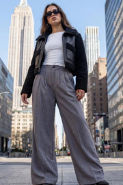 Pantalón de fit wide leg, estampado rayas, cintura alta, pinzas frontales, bolsillos delanteros, cierre frontal con botón y cremallera oculta.