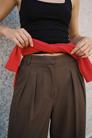 Pantalón de fit wide leg, pinzas frontales, cintura alta con pretina y trabillas, bolsillos delanteros, cierre frontal con broche y cremallera ocultos.