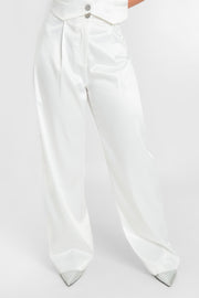 Pantalón satinado de fit wide leg con pinzas frontales, cintura alta con pretina y trabillas, bolsillos delanteros, cierre frontal con botón en contraste y cremallera oculta.