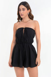 Playsuit strapless de escote recto con plisados y jareta frontal ajustable, cut outs con plisados y lazo amarrable, rib elástico en cintura y olanes en bajo.
