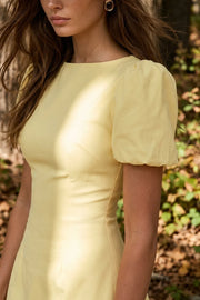 Playsuit de fit ajustado, cuello redondo, manga corta abullonada con plisados en hombros, pinzas frontales, corte en a y cierre con cremallera oculta.