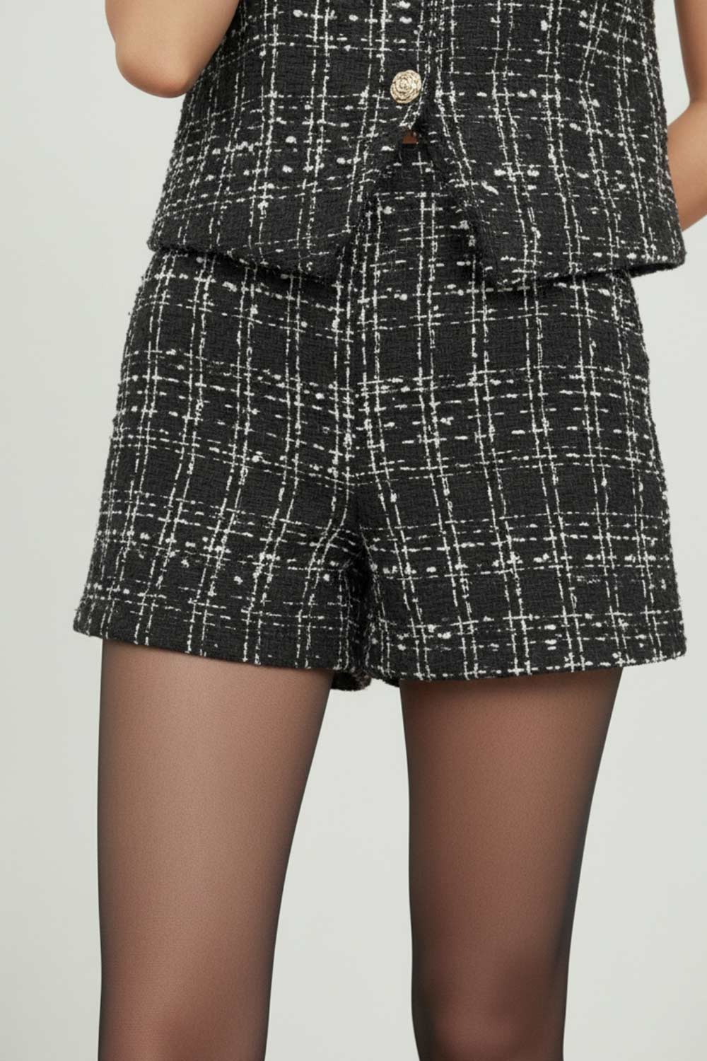 Short corto de bouclé, fit ajustado, cintura alta con pretina, cierre frontal con cremallera oculta y botón en contraste.