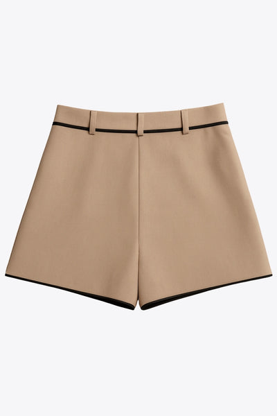 Short de fit recto, cintura alta con pretina y trabillas, bolsillos delanteros, pinzas frontales, cierre frontal con botón y cremallera oculta. Detalle de ribete decorativo en contraste.